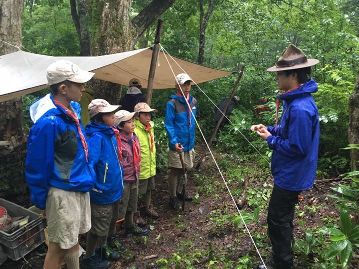 キャンプ2日目の朝、大雨の中でリーダーの点検を受けて朝礼の様子です。